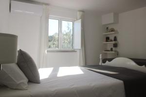 um quarto com uma cama branca com janela em Casas d'Almofala em Vila de Rei mais 30 fotografias