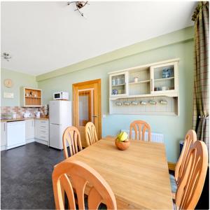 a kitchen and dining room with a wooden table and chairs at The Arches, Borthwick Mains Farm, in Gorebridge