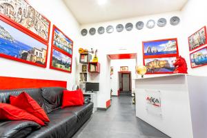 soggiorno con divano in pelle nera e cuscini rossi di Arka Apartments a Napoli