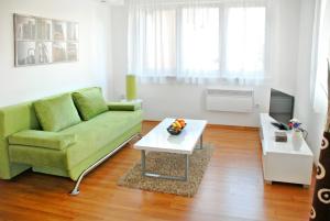 sala de estar con sofá verde y mesa de centro en Modern City Apartments, en Sarajevo