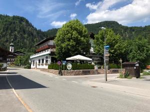 una strada vuota in una piccola cittadina con un edificio di Hotel Almrausch a Reit im Winkl