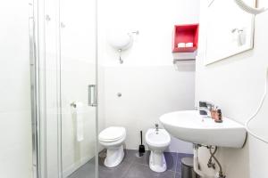 La salle de bains blanche est pourvue de toilettes et d'un lavabo. dans l'établissement Arka Apartments, à Naples