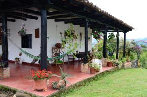 ein Haus mit einer Terrasse mit Topfpflanzen in der Unterkunft Hotel Anacaona in San Agustín