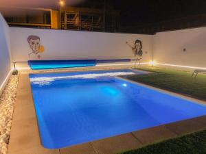 a swimming pool with blue water at night at Up iConik in Aveiro
