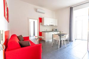 un soggiorno con divano rosso e tavolo di Arka Apartments a Napoli