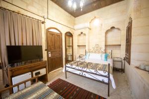 Schlafzimmer mit einem Bett und einem Flachbild-TV in der Unterkunft Hayatlı Konak in Şanlıurfa