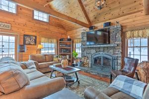 sala de estar con chimenea de piedra y TV en Poconos Family Fun Waterfront Cabin with Deck!, en Nay Aug