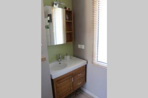 ein Badezimmer mit Waschbecken und Spiegel in der Unterkunft Les Oliviers gîte grand confort au calme classé 3 étoiles in Balazuc + 31 Fotos