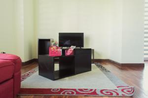 a living room with a tv and a table at Luxstone Executive & Suites in La Paz