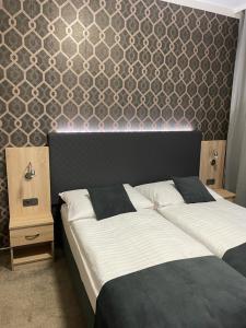 a bedroom with two beds and a wall with a headboard at Penzion Ema B&B in Prostějov