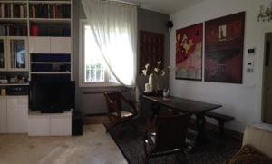 a living room with a dining table and a television at Bed & Breakfast Case Osti in Castel Maggiore