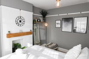 1 dormitorio con 1 cama blanca y 1 silla en Large 2bed House, Heart of Upper Parkstone, Close to Beach - Buckland Heights en Poole