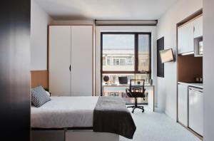 a bedroom with a bed and a desk and a window at Resa Patacona in Valencia