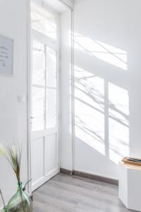 a white room with a window and a vase at La Maison de Famille 3 chambres 8 pers Terrasse Parking Clim in Marseille