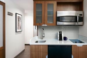 a kitchen with a sink and a microwave at Club Quarters Hotel Grand Central, New York in New York