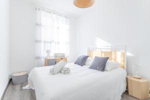 a white bedroom with a large white bed with pillows at La Maison de Famille 3 chambres 8 pers Terrasse Parking Clim in Marseille