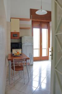 een keuken met een tafel en stoelen en een koelkast bij Casa di Nina in Salerno