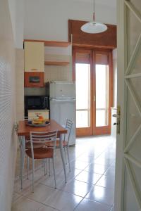 サレルノにあるCasa di Ninaのテーブルと椅子と冷蔵庫のあるキッチン