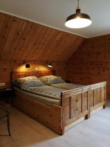 Cama grande en habitación con paredes de madera en Landhaus Gritschacher, en Sankt Peter in Holz