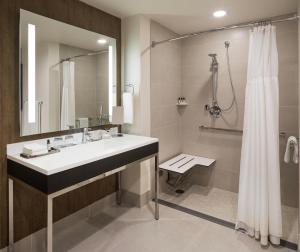 a bathroom with a shower, sink, and mirror at Hyatt Regency Bloomington in Bloomington