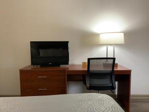 a bedroom with a desk with a television and a chair at Econo Lodge Troy in Troy