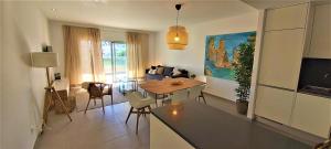 Albufeira beach apartment في ألبوفيرا: مطبخ وغرفة معيشة مع طاولة وأريكة