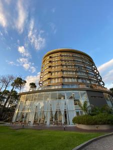 a large building with glass windows on the side of it at Hotel Zentiva Pinamar in Pinamar