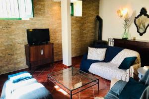 a living room with a couch and a tv at La Casa Flores, maison traditionnelle portugaise in Odeceixe