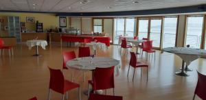 jadalnia ze stołami i czerwonymi krzesłami w obiekcie Hotel Lago Losetta w mieście Sestriere