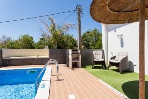 un patio trasero con piscina y una casa en CoolHouses Algarve, Casa Marisa, V5 Burgau, en Burgau