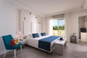 ein Schlafzimmer mit einem großen Bett und einem blauen Stuhl in der Unterkunft Astoria Suite Hotel in Rimini