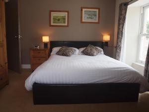 a bedroom with a large white bed with two pillows at Herriot's in Hawes