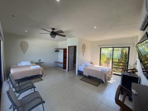 a hotel room with two beds and a television at Cuxos Hotel Beachfront in Isla Mujeres