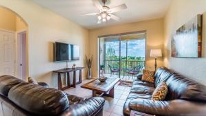 a living room with a leather couch and a tv at The Ultimate 5 Star Condo on Windsor Hills Resort, Orlando Condo 4782 in Orlando