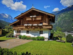 una casa en las montañas con un patio en Ferienwohnungen Fichtenheim, en Mayrhofen