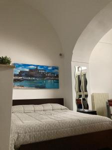 sypialnia z łóżkiem i obrazem na ścianie w obiekcie Piazza grande w mieście Polignano a Mare