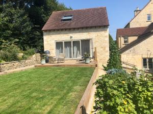 a backyard with a lawn and a house at Cotswold Lodge in Painswick