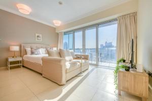 a bedroom with a couch and a large window at Prime Retreats - Downtown Dubai in Dubai