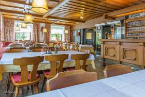 a dining room with tables and chairs in a restaurant at Gasthof Neuhofen in Eugendorf