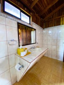 a bathroom with a sink and a mirror at ARENAL ROCA LODGE in Fortuna