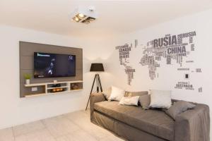 a living room with a couch and a flat screen tv at Temporales Ushuaia - Bahia loft in Ushuaia