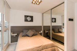 a bedroom with a bed and a mirror at Temporales Ushuaia - Bahia loft in Ushuaia