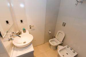 a white bathroom with a sink and a toilet at Temporales Ushuaia - Bahia loft in Ushuaia +21 photos