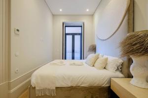 1 dormitorio con 1 cama con sábanas blancas y ventana en BOUTIQUE Rentals- Art & Charm Apt w/ balcony & garage en Oporto