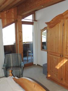 a bedroom with a bed and a chair and a window at FW Zauberblick in Zwiesel
