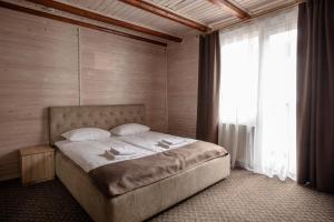 Postel nebo postele na pokoji v ubytování Dovbushanka Hotel
