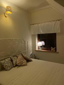 um quarto com uma cama e uma janela com um candeeiro em Lawendowe Siedlisko em Suwałki