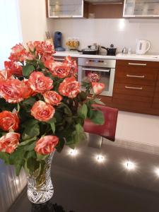 a vase filled with red roses in a kitchen at Lux Apartment, Liko Grad in Kyiv