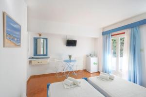 Dieses weiße Zimmer verfügt über 2 Betten und ein Fenster. in der Unterkunft Hotel Asteroa in Antikes Epidauros