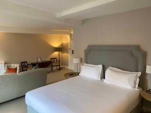 a bedroom with a large bed and a living room at The Bull Inn in Woodbridge